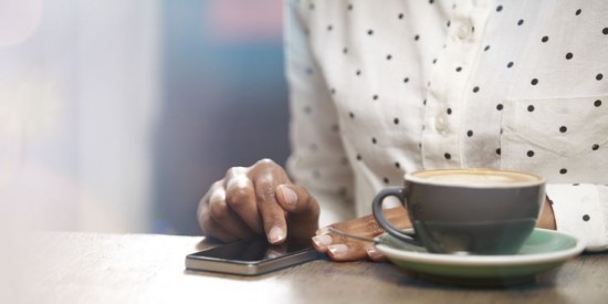 femme prend un cafe en etant sur son smartphone
