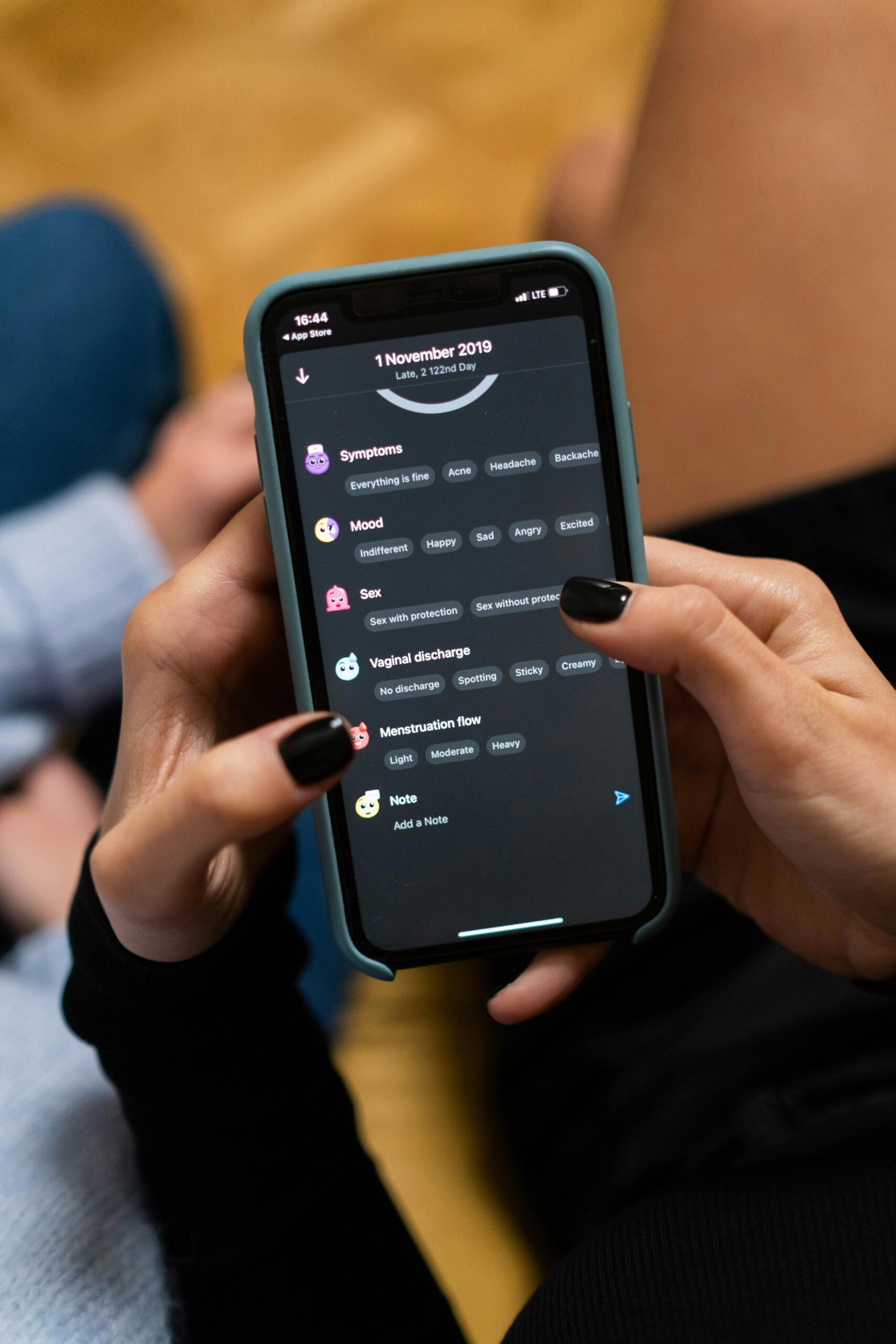 Close-up of woman using a smartphone health tracking app, focusing on personal wellness data.