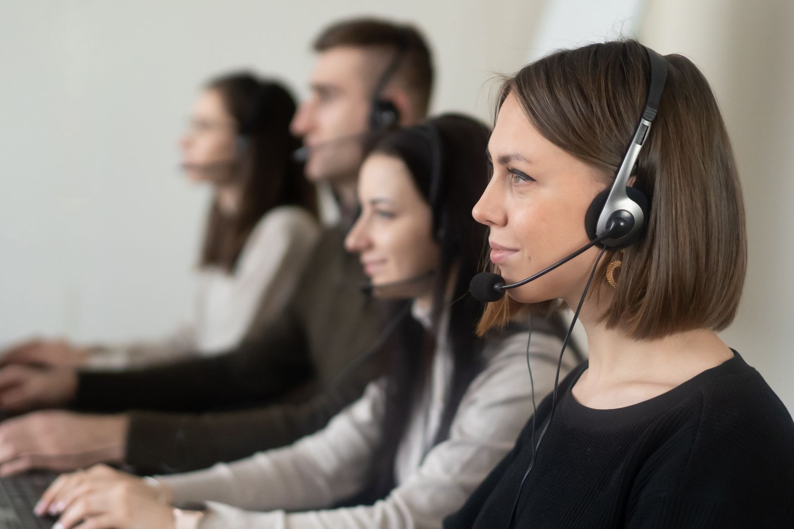 Equipo de atención telefónica con auriculares en una oficina, ilustrando el uso de un asistente de voz con IA